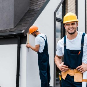 selective-focus-of-happy-handyman-in-uniform-near-coworker.jpg